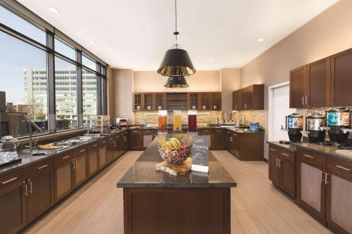 a large kitchen with wooden cabinets and a bowl of fruit at Homewood Suites by Hilton Washington DC Capitol-Navy Yard in Washington