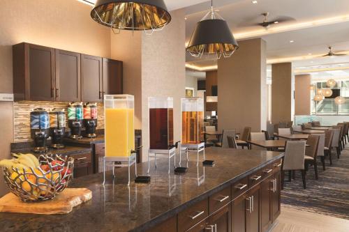 a kitchen with a bar with chairs and tables at Homewood Suites by Hilton Washington DC Capitol-Navy Yard in Washington