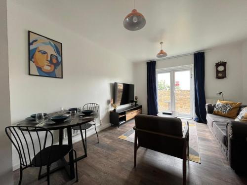 a living room with a table and a couch at KENT, DARTFORD STATION APARTMENTs in Dartford