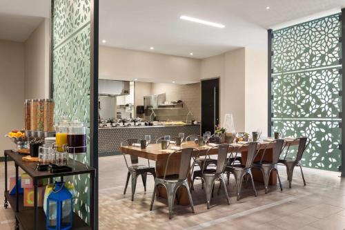 a dining room with a table and chairs and a kitchen at Hilton Garden Inn Boulder in Boulder