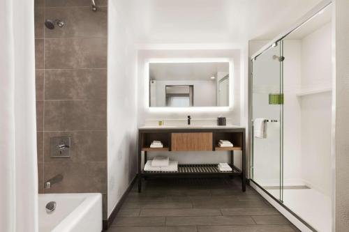 a bathroom with a sink and a tub and a mirror at Hilton Garden Inn Boulder in Boulder