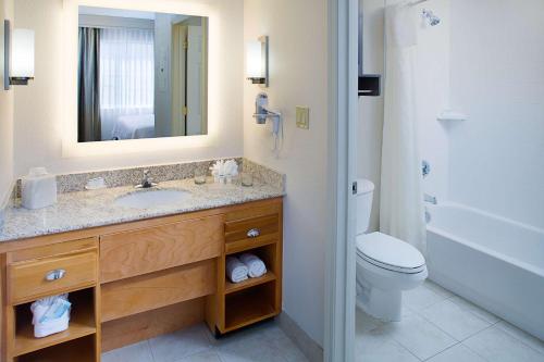 a bathroom with a sink and a toilet and a mirror at Homewood Suites by Hilton Albuquerque Uptown in Albuquerque