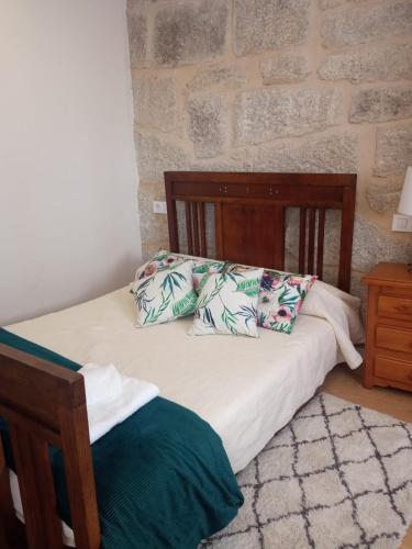 a bedroom with a bed with two pillows on it at O Noso Lar - RIBEIRA SACRA in Nogueira de Ramuin