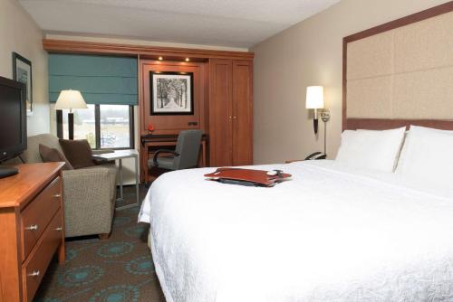 a hotel room with a large bed and a desk at Larkspur Landing Ann Arbor in Ann Arbor