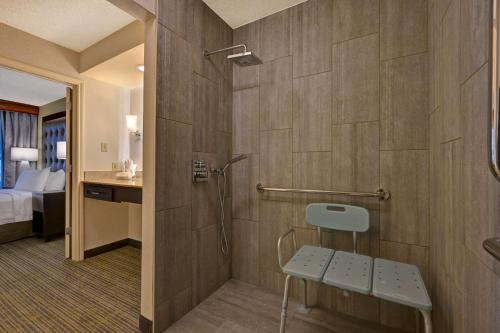 a bathroom with a shower with a bench in it at Homewood Suites by Hilton Boulder in Boulder