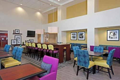 um restaurante com mesas e cadeiras e uma sala de jantar em Hampton Inn & Suites Bloomington Normal em Normal