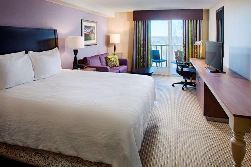 a hotel room with a bed and a desk with a computer at Hilton Garden Inn Hartford North-Bradley International Airport in Windsor