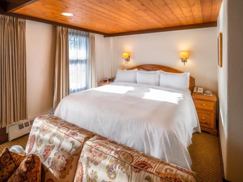 a bedroom with a large white bed and a window at Post Hotel & Spa in Lake Louise