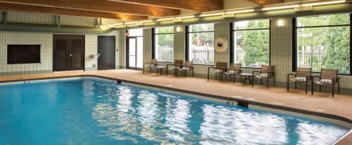 a large swimming pool with chairs and windows at DoubleTree by Hilton Hotel Chicago - Schaumburg in Schaumburg