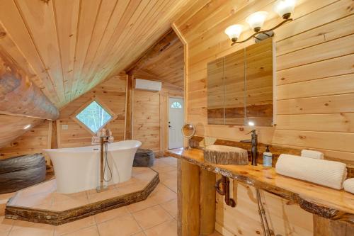 a bathroom with a tub in a log cabin at Secluded Greenville Cabin Walk to Moosehead Lake! in Greenville