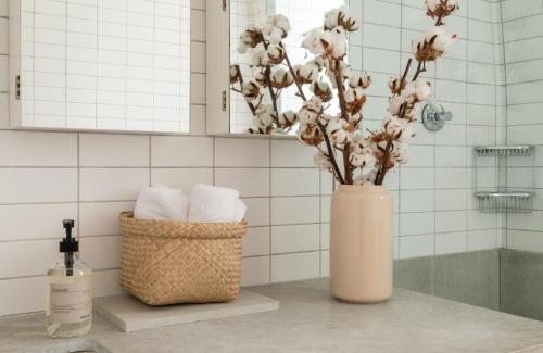 a pink vase with flowers on a counter in a bathroom at The Leicester Square Apartment By Hok Living in London