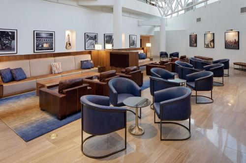 a salon with a waiting room with blue chairs at Hilton Nashville Airport in Nashville