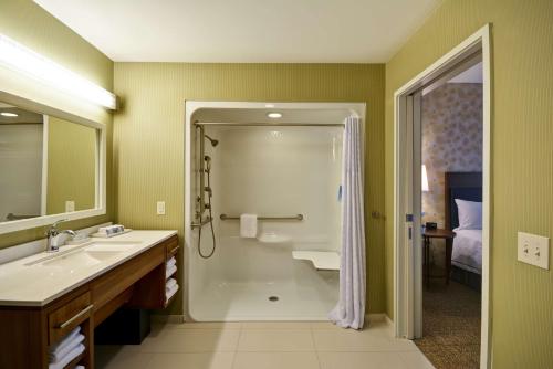 a bathroom with a shower and a sink and a tub at Home2 Suites By Hilton Decatur Ingalls Harbor in Decatur