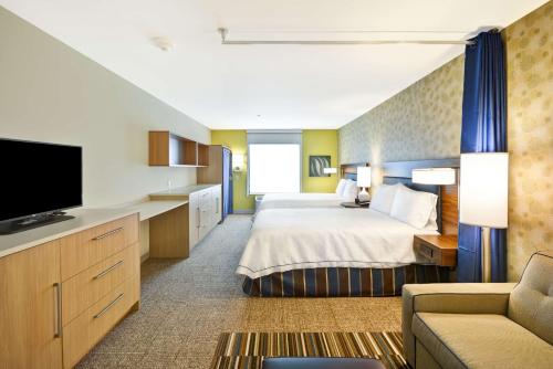 Habitación de hotel con cama y TV en Home2 Suites By Hilton Decatur Ingalls Harbor en Decatur