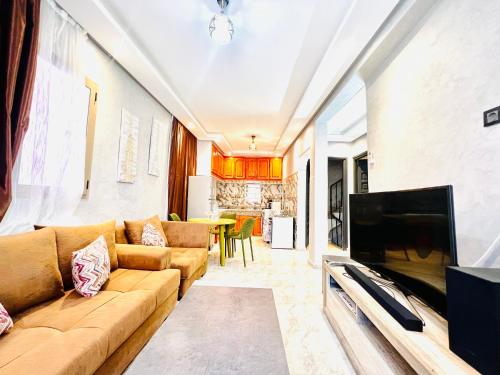 a living room with a couch and a flat screen tv at Al Hanae Family Aparts in Marrakesh