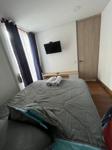 a bedroom with a large bed with two towels on it at Wohnung Queens Deluxe in Bogotá