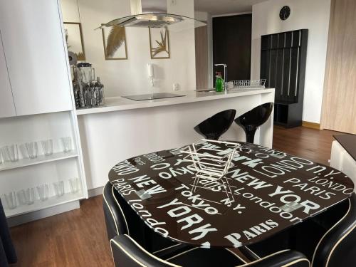 a dining room table with black chairs and a kitchen at Wohnung Queens Deluxe in Bogotá
