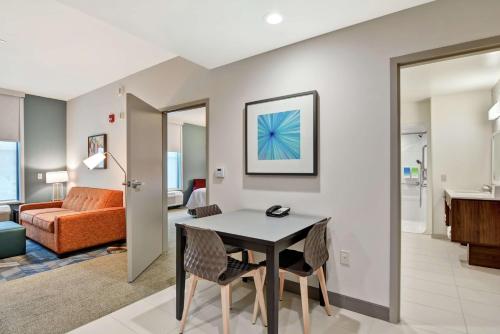 a living room with a table and chairs in a room at Home2 Suites By Hilton Madison Huntsville Airport in Madison