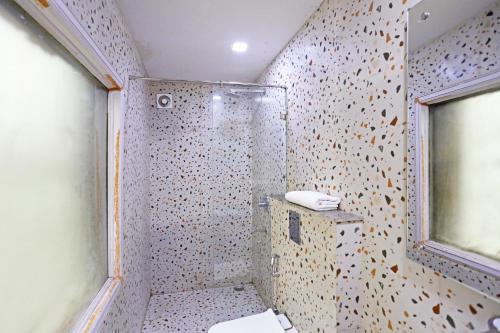 a bathroom with a shower with a toilet and a window at Hotel Preet Palace -5 Mints Walk From Nizamuddin Railway Station in New Delhi