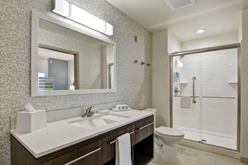 ein Badezimmer mit einem Waschbecken, einem WC und einem Spiegel in der Unterkunft Home2 Suites By Hilton Madison Huntsville Airport in Madison
