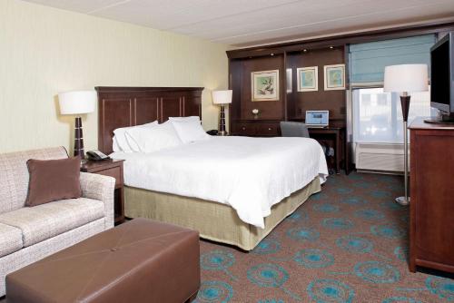 a hotel room with a large bed and a couch at Hampton Inn & Suites Kokomo in Kokomo