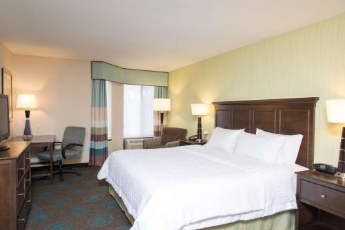 a hotel room with a large bed and a desk at Hampton Inn & Suites Kokomo in Kokomo