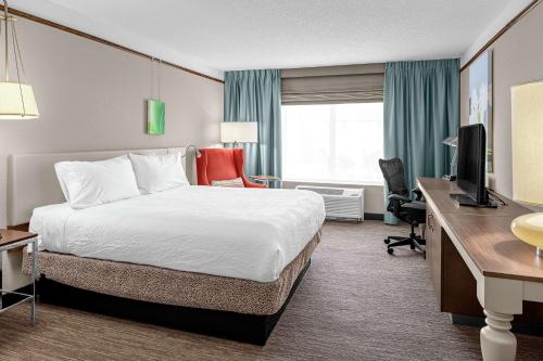 Cette chambre comprend un lit et un bureau. dans l'établissement Hilton Garden Inn Wilmington Mayfaire Town Center, à Wilmington