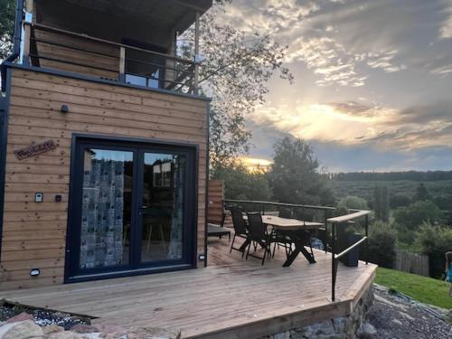 a wooden deck with a table and chairs on a house at Chez Laurette in Frémifontaine