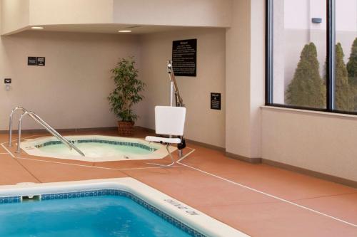 a spa room with a jacuzzi tub in a building at Hampton Inn Muskegon in Muskegon Heights