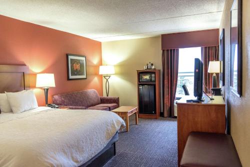 a hotel room with a bed and a television at Hampton Inn Muskegon in Muskegon Heights