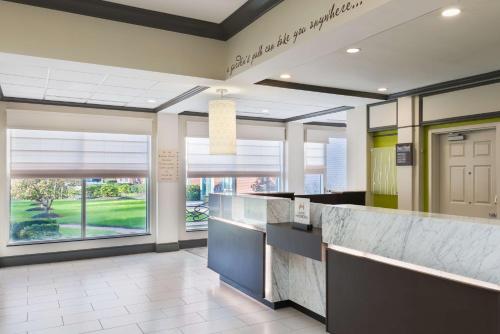 a lobby of a hospital with a counter and windows at Hilton Garden Inn Westbury in Westbury