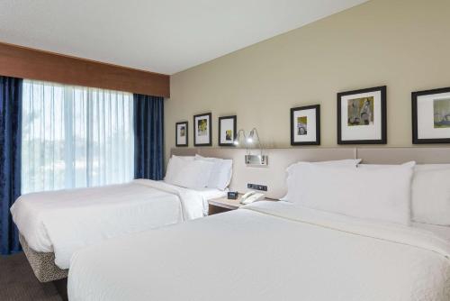a hotel room with two beds and a window at Hilton Garden Inn Westbury in Westbury