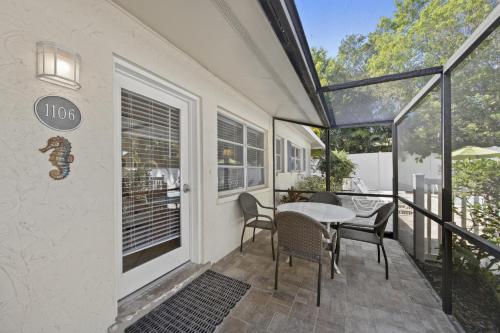 a patio with a table and chairs on a balcony at Sandy Seahorse Cottage in Siesta Key