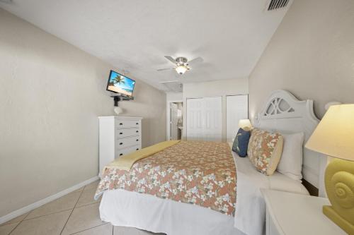 a bedroom with a bed and a television in it at Sandy Seahorse Cottage in Siesta Key