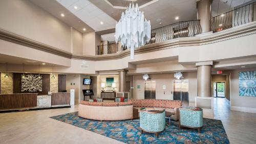 a lobby with a chandelier and a waiting room at DoubleTree by Hilton Hotel West Palm Beach Airport in West Palm Beach