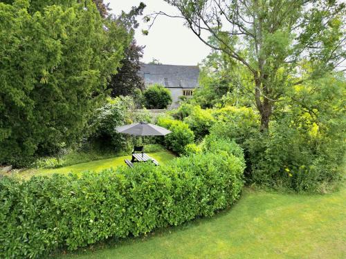 a table with an umbrella in a garden at The Mount Somerton Retreat - Nr Bruton, Glastonbury, The spectacular Wells Cathedral, Millfield School, Leonardo Helicopters, Yeovilton in Somerton