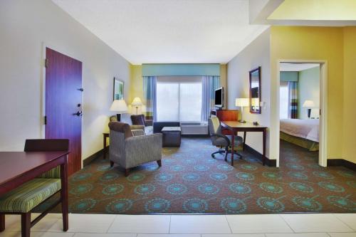 Habitación de hotel con cama y sala de estar. en Hampton Inn & Suites South Bend, en South Bend