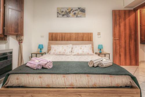 een slaapkamer met een groot bed met 4 kussens bij La Casa Del Saraceno in Civitavecchia
