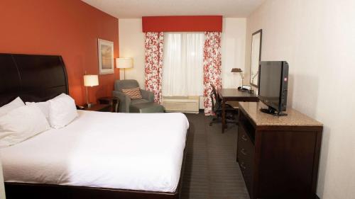 a hotel room with a bed and a flat screen tv at Hilton Garden Inn Springfield, IL in Springfield