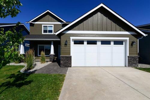 a house with white garage doors in a driveway at CDA Hideaway 4 bed 3 Bath Modern Mid Term Rental in Hayden