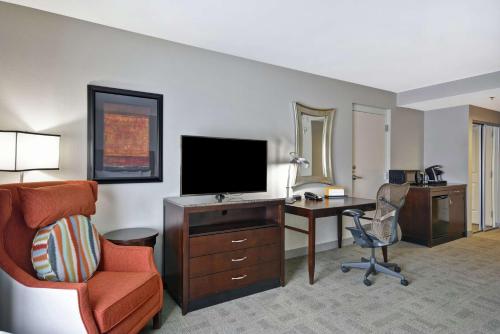 a hotel room with a desk and a television and a chair at Hilton Garden Inn Toledo / Perrysburg in Perrysburg