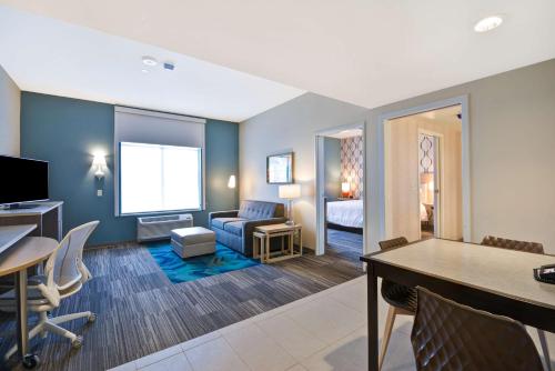 a living room with a room with a couch and a table at Home2 Suites by Hilton Perrysburg Levis Commons Toledo in Perrysburg
