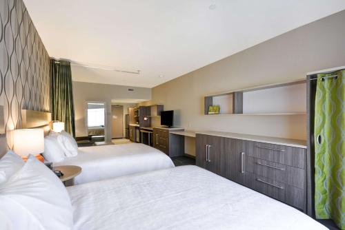 a hotel room with two beds and a kitchen at Home2 Suites by Hilton Perrysburg Levis Commons Toledo in Perrysburg