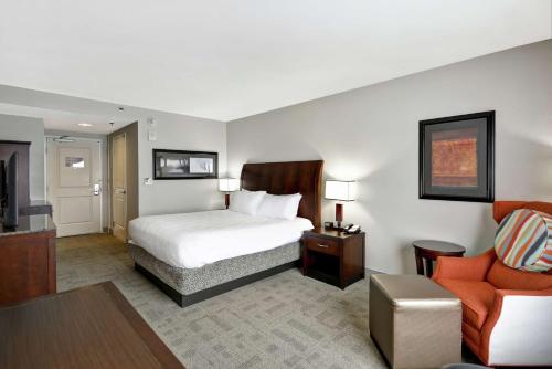 a hotel room with a bed and a living room at Hilton Garden Inn Toledo / Perrysburg in Perrysburg