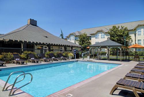 a pool at a hotel with chairs and a building at Homewood Suites by Hilton Vancouver / Portland in Vancouver