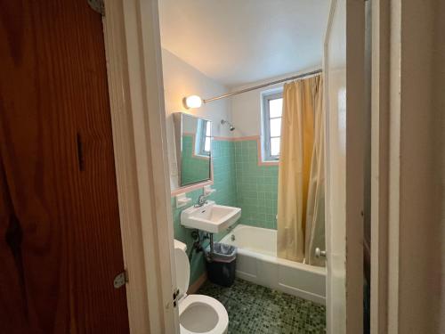 ein Badezimmer mit einem Waschbecken, einem WC und einem Spiegel in der Unterkunft Sherbrooke All Suites Hotel in Miami Beach