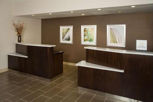 a lobby with two counters and paintings on the wall at DoubleTree by Hilton Hotel Chicago Wood Dale - Elk Grove in Wood Dale