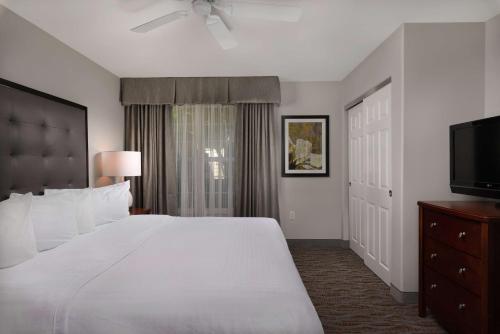 a bedroom with a large white bed and a flat screen tv at Homewood Suites by Hilton Vancouver / Portland in Vancouver