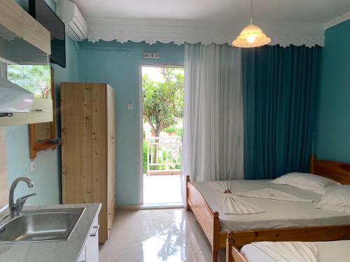 a bedroom with a bed next to a sink and a window at VILLA STATHIS in Nea Vrasna