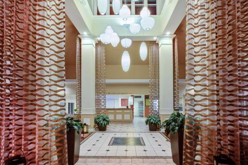 eine Lobby mit Säulen und Pflanzen in einem Gebäude in der Unterkunft Hilton Garden Inn Chesterton in Chesterton